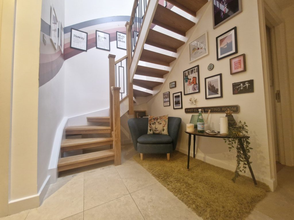 Oak staircase with solid oak handrails, newel posts and black metal spindles