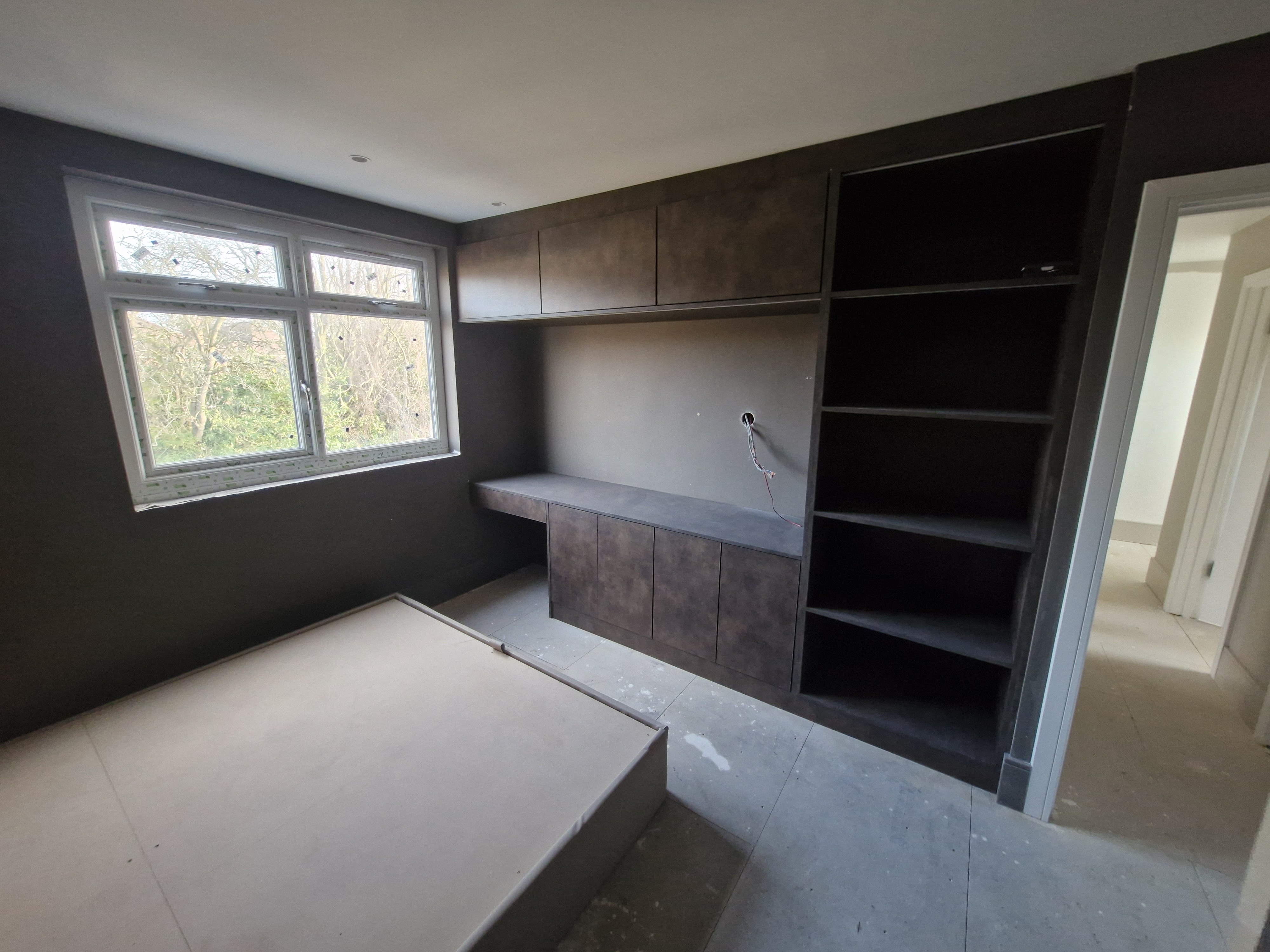 Bespoke dark fitted home office with desk, cupboards and open shelving