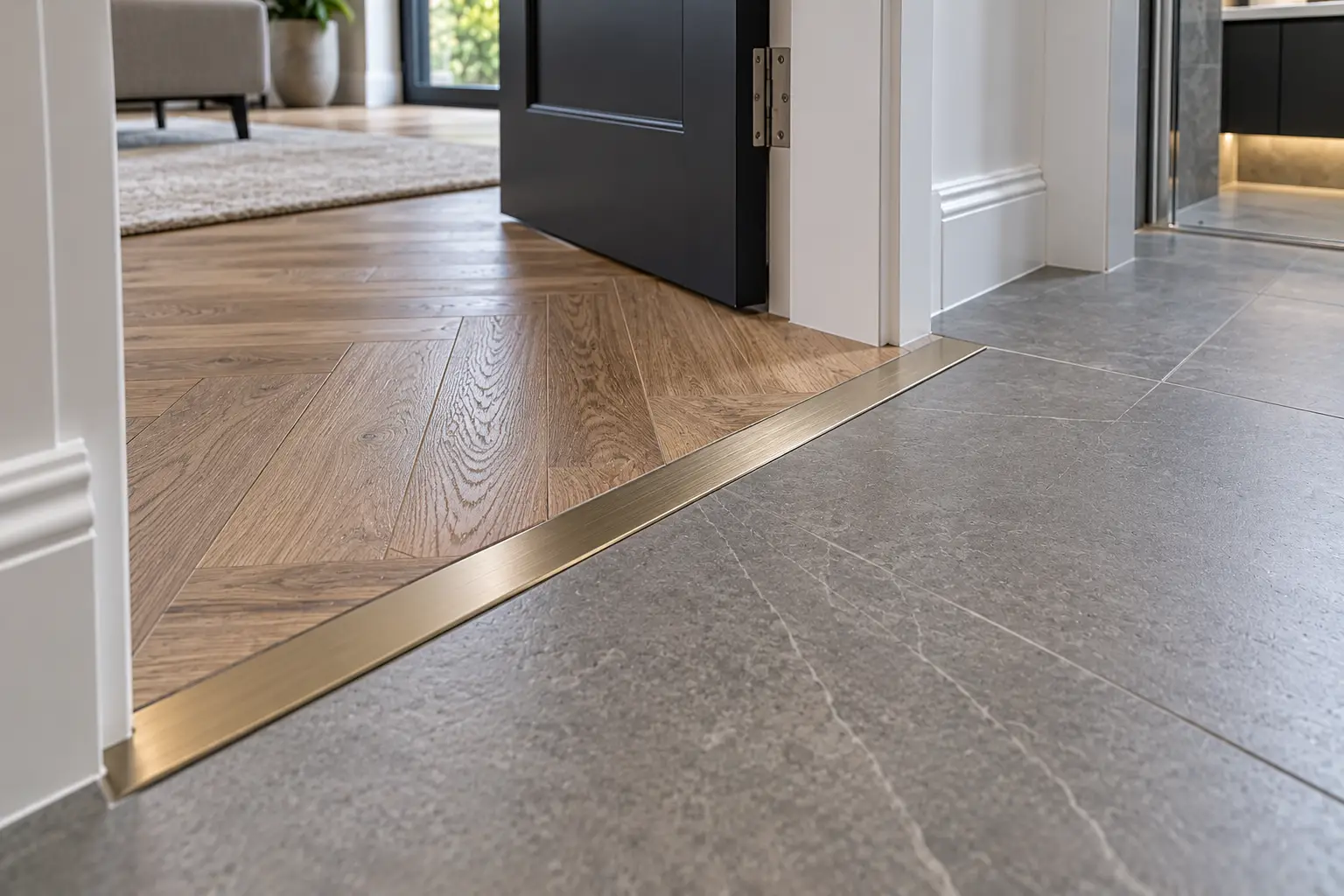 Precision flooring transition between herringbone wood flooring and tiles with a brass threshold in Leeds